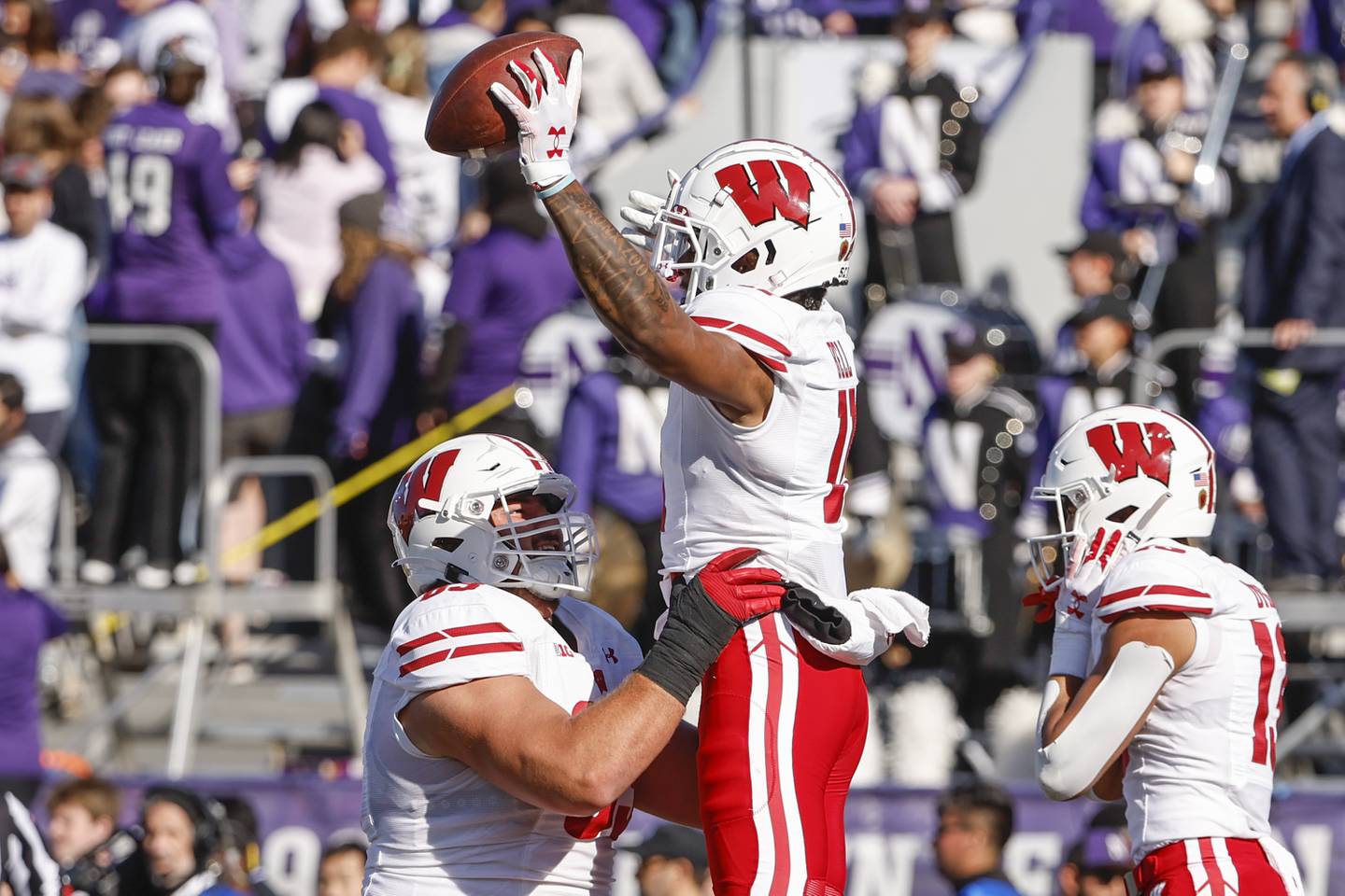 Wisconsin offensive lineman Tanor Bortolini, left, lifts wide receiver Skyler Bell after Bell scored a touchdown against Northwestern on Saturday in Evanston. 