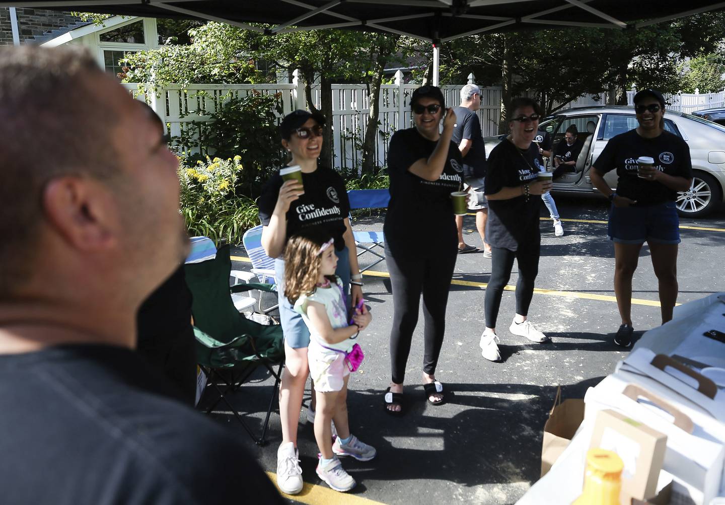 Employees of Berkshire Hathaway HomeServices Chicago listen to John Lawrence, a vice president in Berkshire's Oak Park office, while working a community shred event at First Presbyterian Church in River Forest on Sept. 17, 2022.