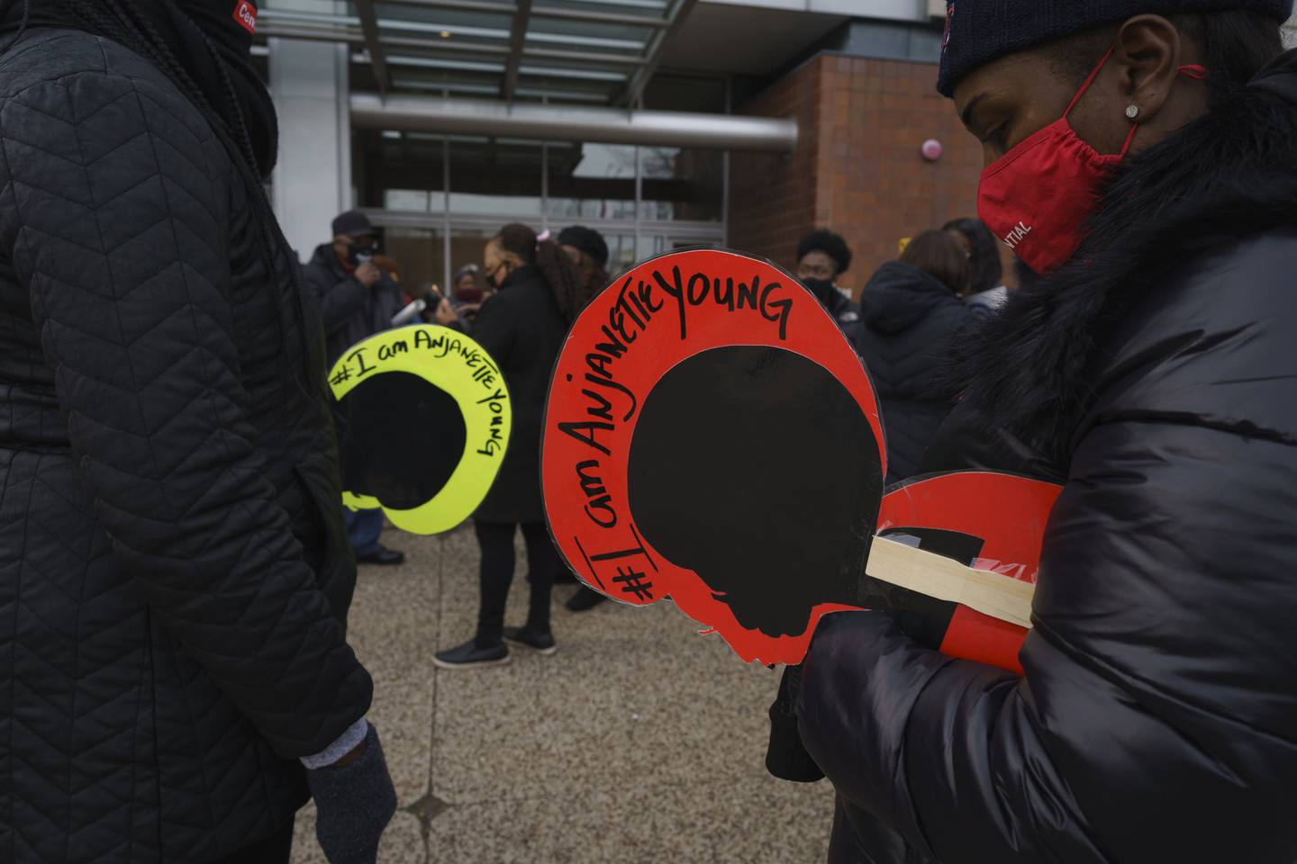 People hold signs that read "I am Anjanette Young" in front of Chicago Police Headquarters as people gather in support of Young in Chicago on Dec. 27, 2020. 