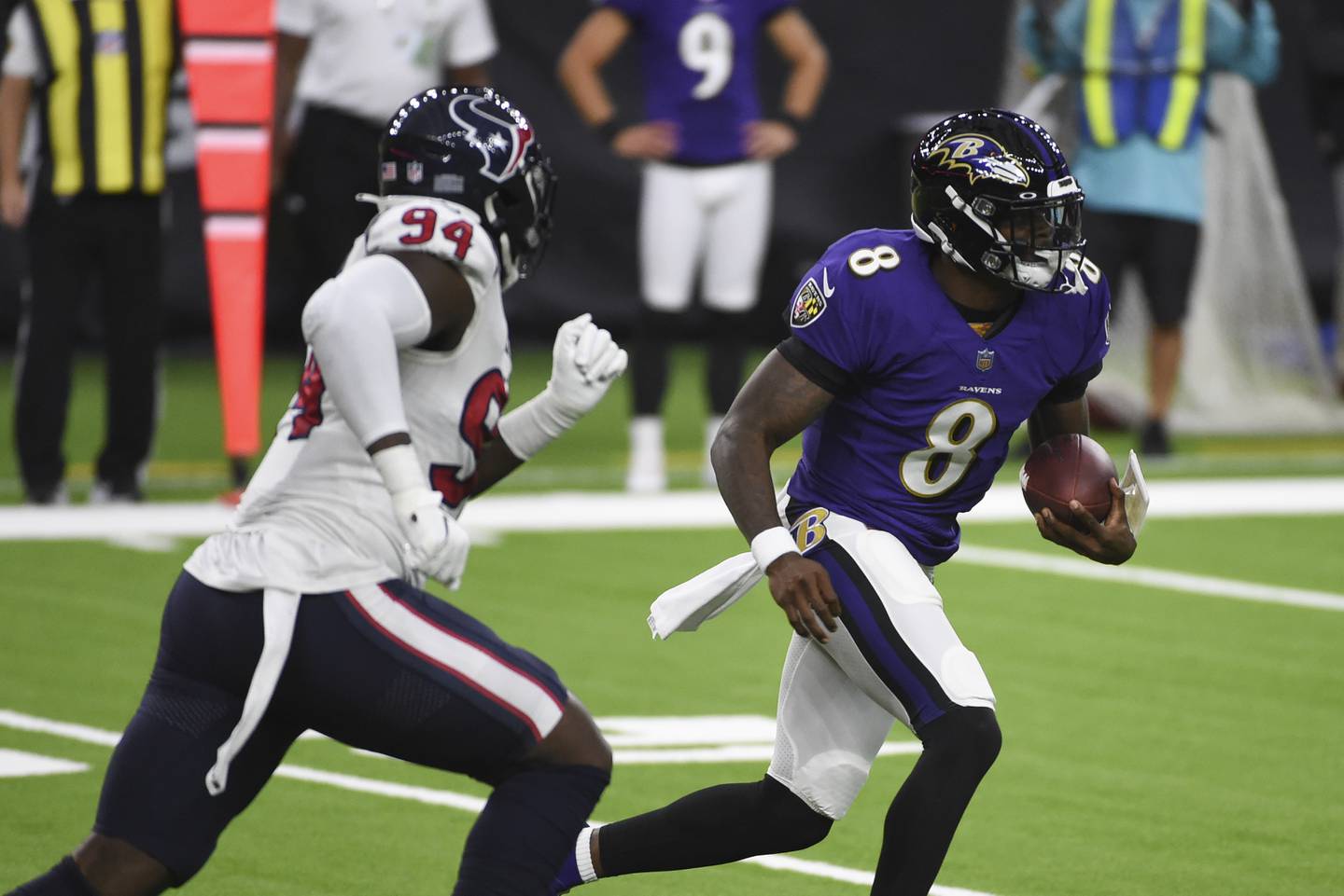 Ravens quarterback Lamar Jackson (8) runs from Texans defensive end Charles Omenihu during the first half on Sept. 20, 2020, in Houston. 