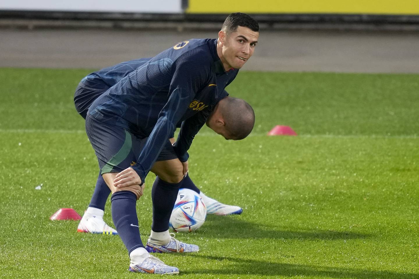 Cristiano Ronaldo stretches with teammate Pepe, in the background, during a Portugal training session Monday, Nov. 14, 2022, in Lisbon.
