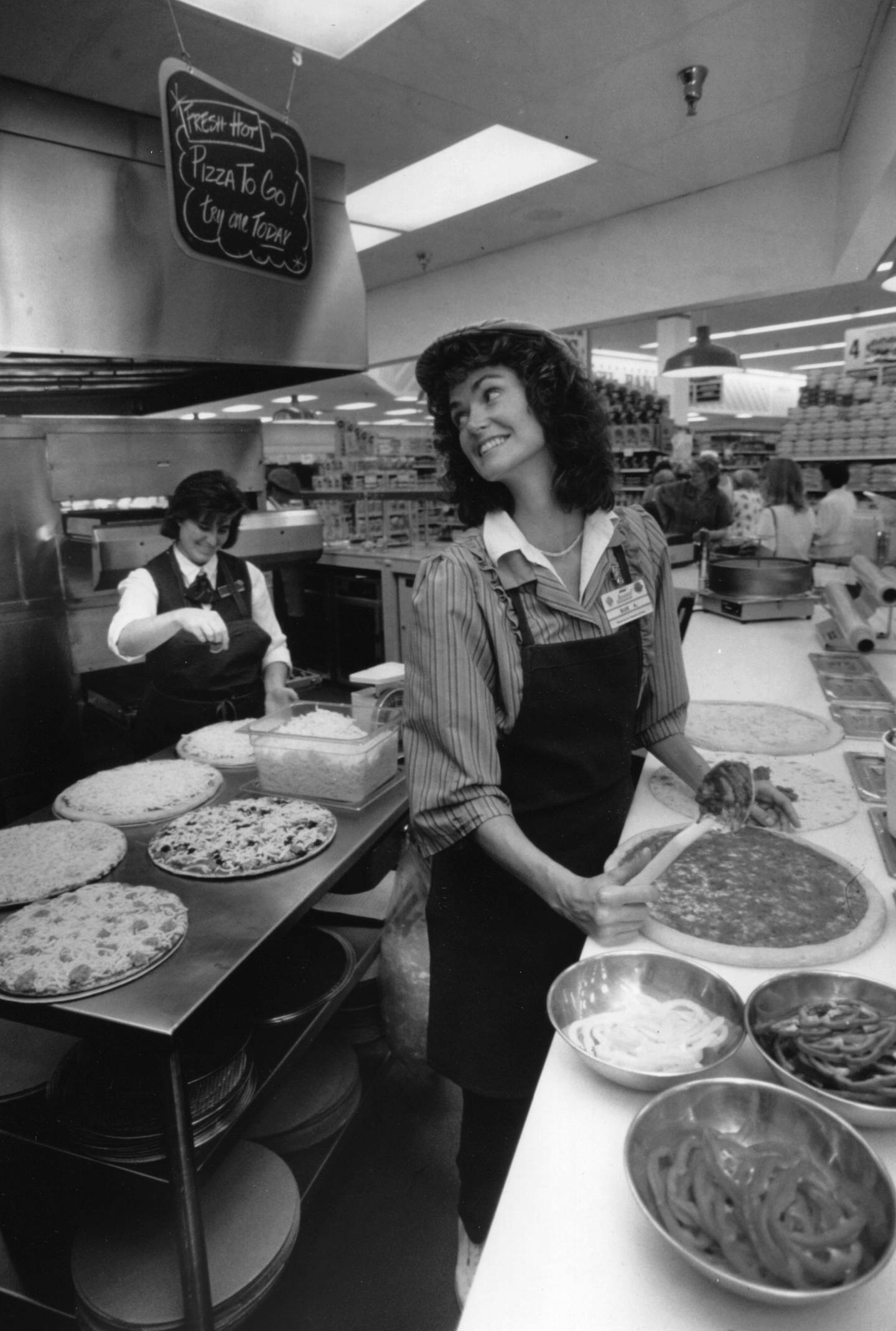 Jewel employee Sue Anderson and deli manager Lisa Burke prepare pizza for baking in Arlington Heights on Sept. 6, 1991. 