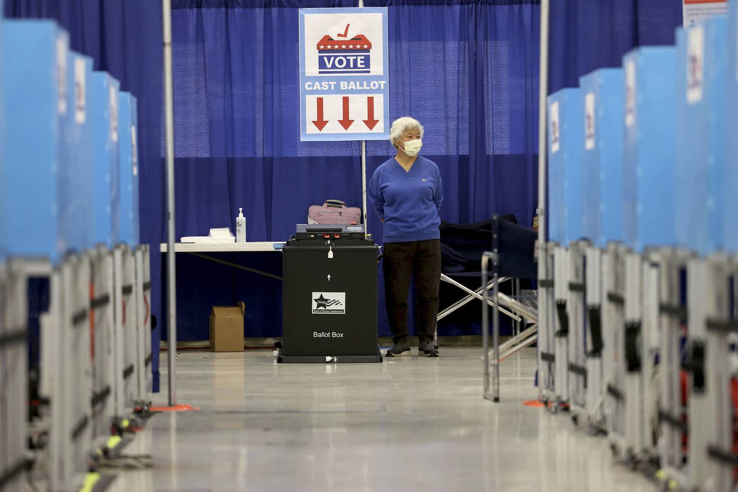 Election official Simona Ip waits for voters, as voters casts their ballots during the first day of early voting for the 2022 General Election at the Chicago Board of Elections Super Site on Oct. 7, 2022.