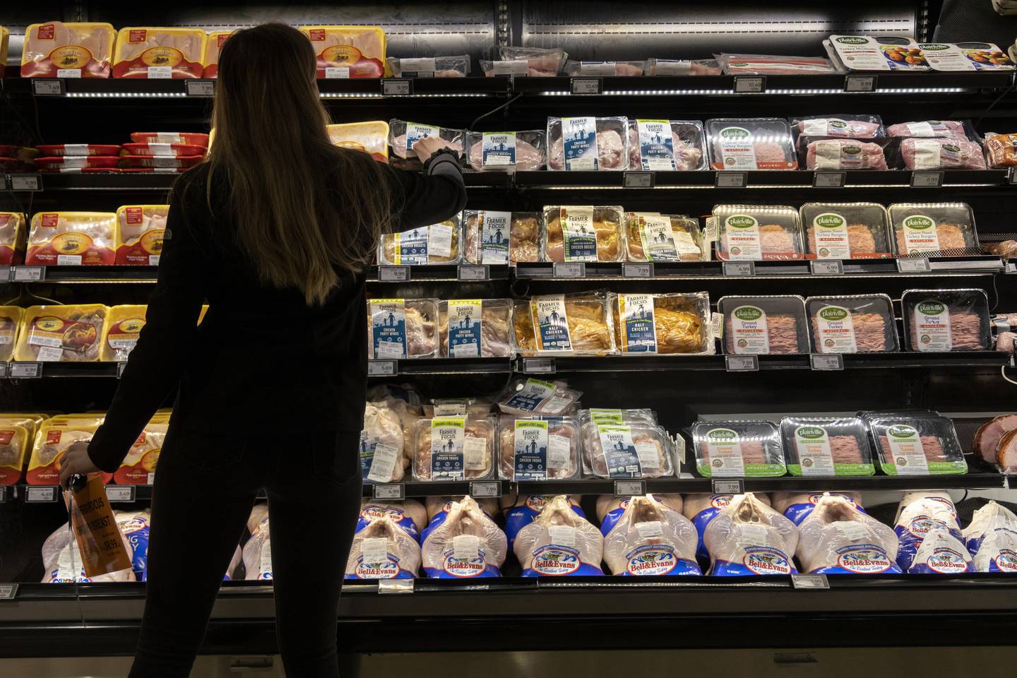 A customer shops in the meat section at Dom's Kitchen & Market on Nov. 15, 2022, in Chicago.