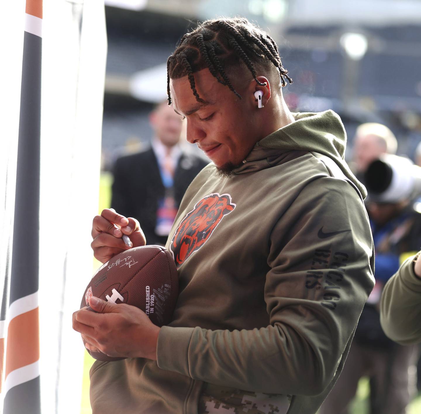 Bears quarterback Justin Fields signs autographs for fans before a game against the Lions at Soldier Field on Nov. 13, 2022.