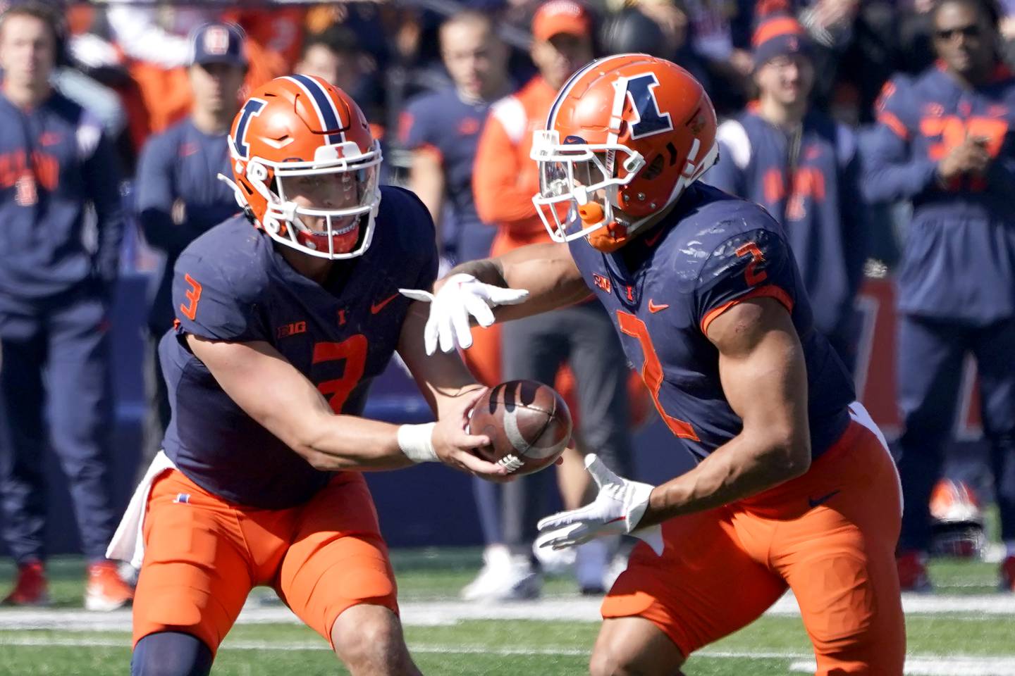 Illinois quarterback Tommy DeVito hands off to running back Chase Brown during a game against Minnesota on Oct. 15 in Champaign. 