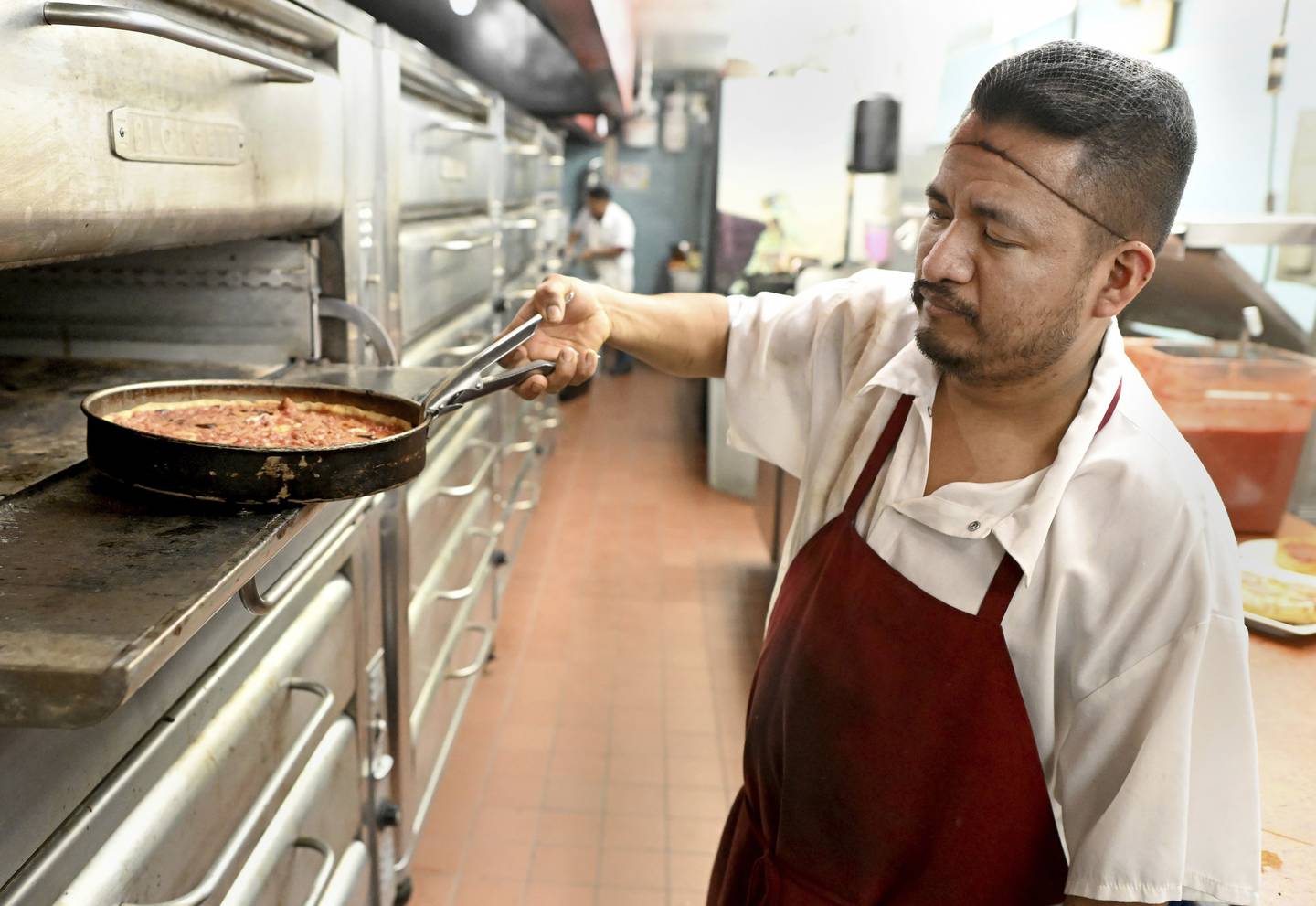 Martin San Agustin works as a line cook at the Lou Malnati’s restaurant in Buffalo Grove on Sept. 19, 2022.