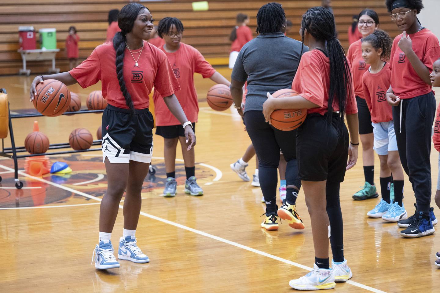 Chicago Sky guard and Gary West Side graduate Dana Evans speaks to participants as they run drills during the inaugural Dana Evans Youth Basketball Camp on Aug. 8, 2022, in Gary.