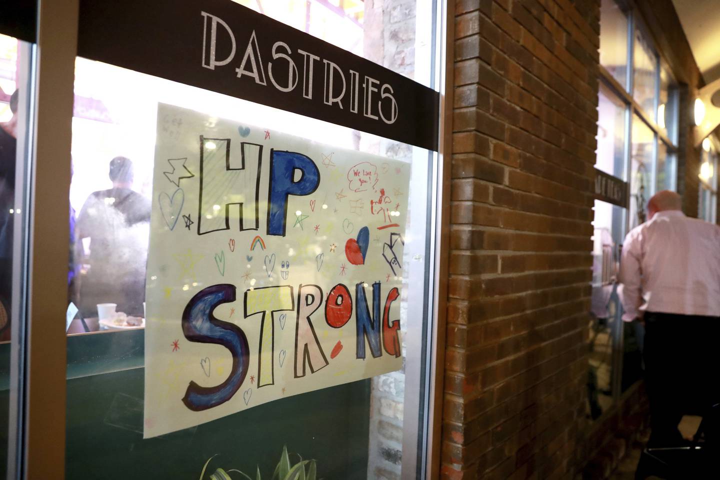 A hand-made HP Strong sign is seen hanging in the window of Madame Zuzu’s teashop in Highland Park on July 27, 2022, as musician Billy Corgan hosts a virtual concert to benefit the victims of the mass shooting that occurred during the Fourth of July parade.