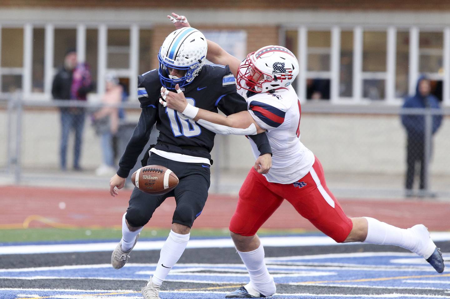 St. Rita's Matt Kingsbury, left, tackles St. Charles North punter Aedan Hayes (18) during a Class 7A state quarterfinal game in St. Charles on Saturday, Nov. 12, 2022.