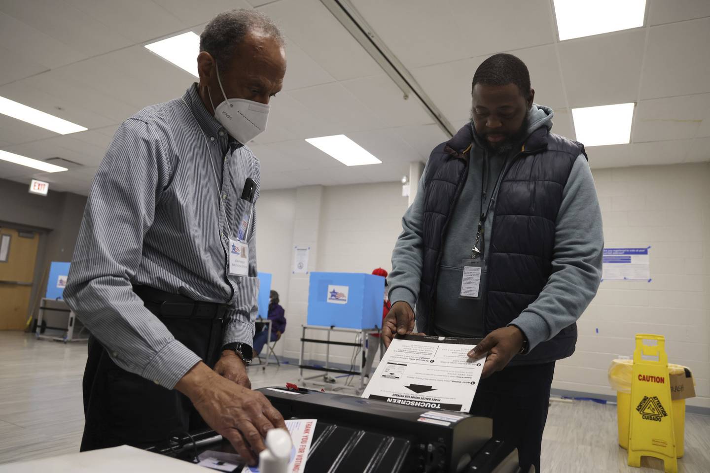 Voting official John Parker, left, helps Lamontriale Hale submit his ballot during early voting at the South Side YMCA on Nov. 7, 2022, in Chicago.