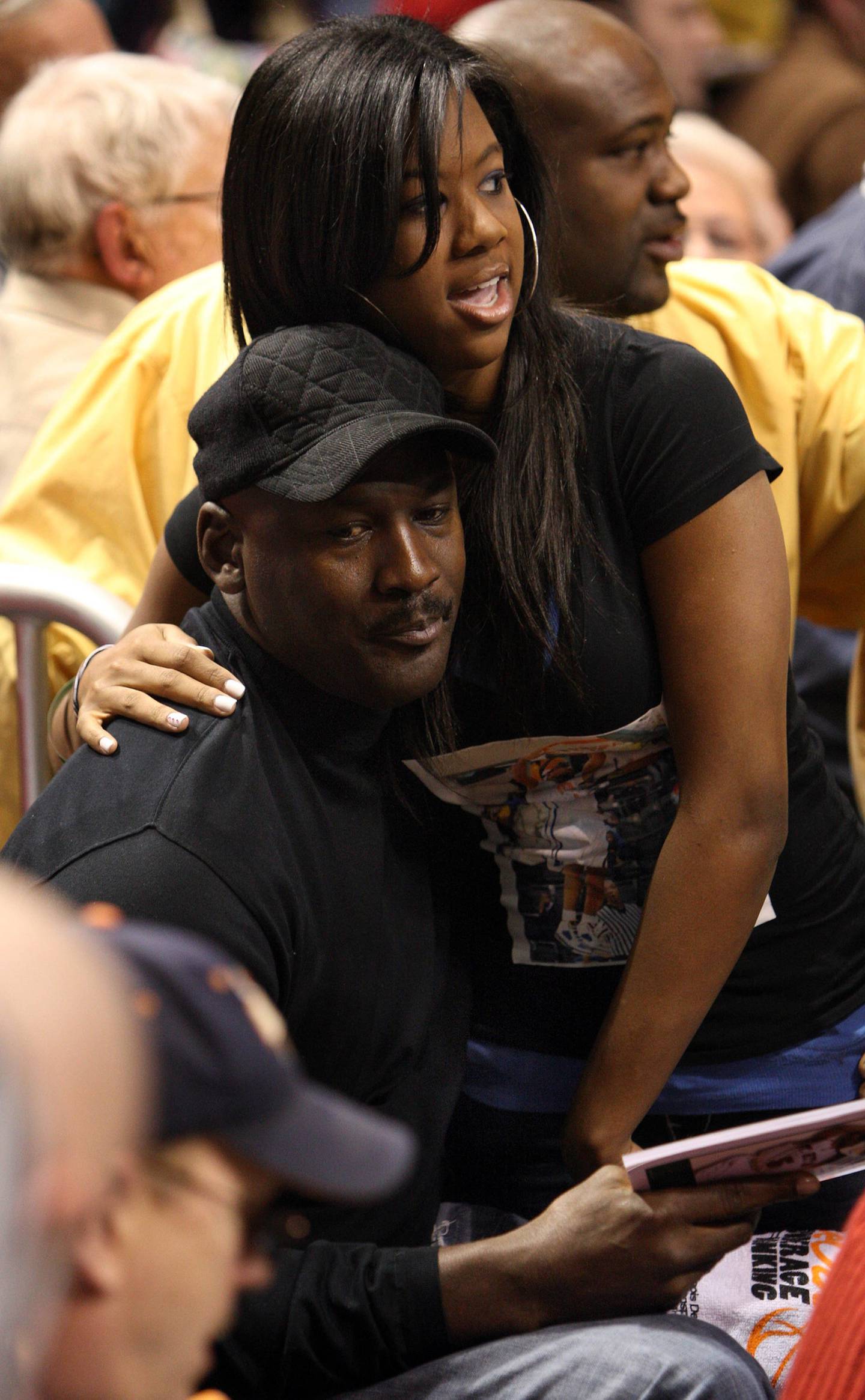 Michael Jordan with his daughter Jasmine, wearing a shirt with her brother Marcus' picture on it, before a Class 4A state semifinal game between Young and Thornton in 2009.