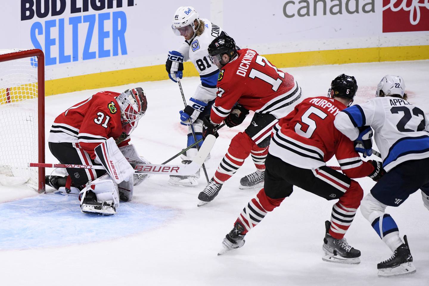 Blackhawks goaltender Dylan Wells makes a save on the Jets' Kyle Connor (81) as Jason Dickinson (17) defends during the third period Saturday in Winnipeg, Manitoba.