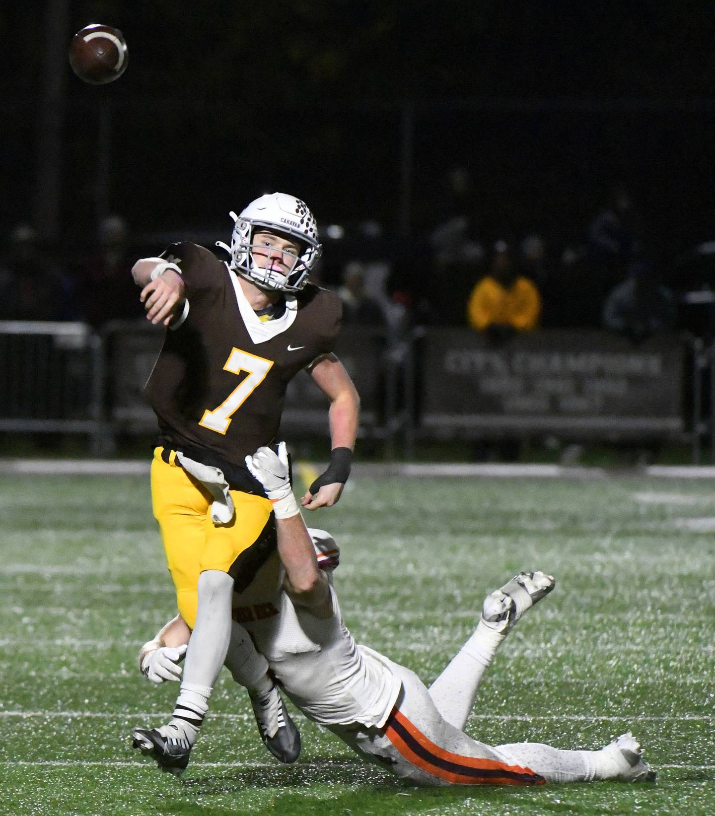 Mount Carmel's Blainey Dowling (7) gets a pass off as Brother Rice's Henry Ivers tries to bring him down during a Class 7A state quarterfinal game in Chicago on Saturday, Nov. 12, 2022.