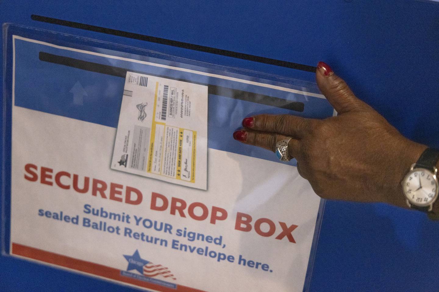 Early-voting official Debra Smith points to a mail-in-ballot box at Whitney M. Young Library on Oct. 28, 2022, in Chicago.
