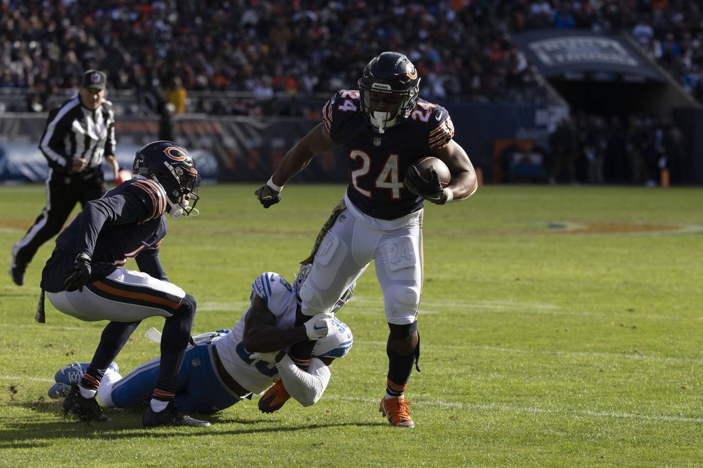 Bears running back Khalil Herbert leg is tugged on by Lions safety C.J. Moore during a game on Oct. 13, 2022, at Soldier Field. 