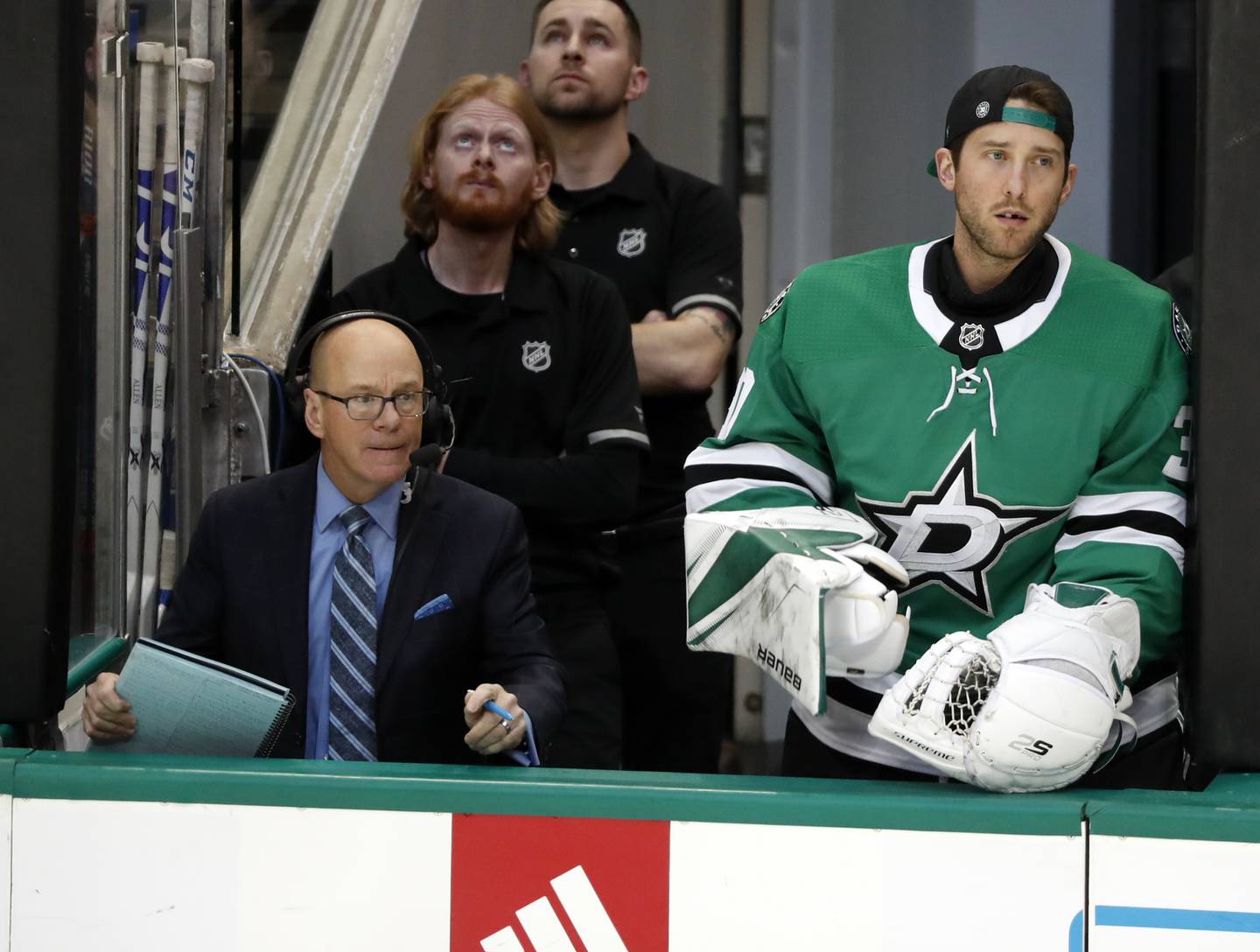 Blues color analyst Darren Pang, left, and Stars goaltender Ben Bishop watch play during a game in Dallas on Feb. 21, 2019.