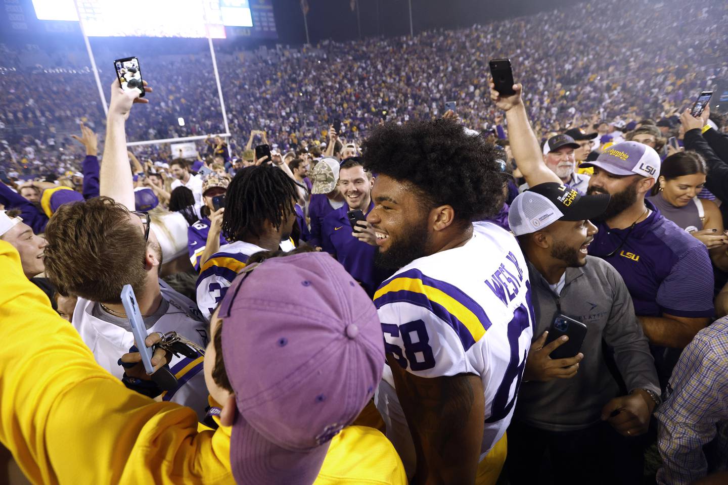 LSU offensive lineman Fitzgerald West Jr. celebrates with fans who gathered on the field after LSU defeated Alabama in overtime on Nov. 5, 2022.