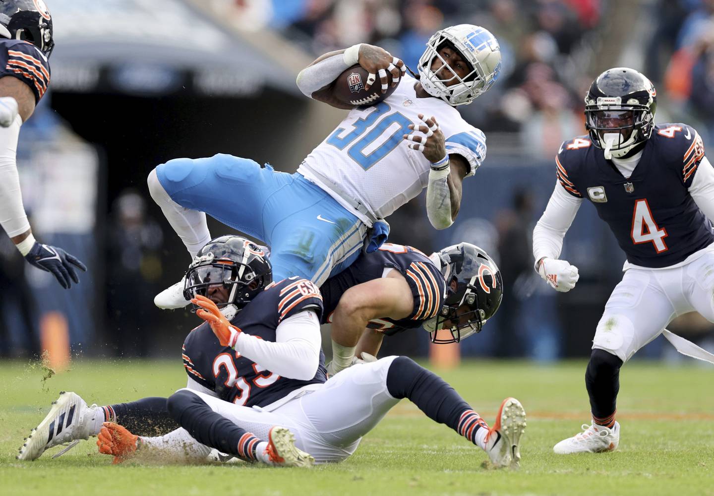 Bears cornerback Jaylon Johnson (33) and linebacker Jack Sanborn (57) tackle Lions running back Jamaal Williams in the second quarter at Soldier Field on Nov. 13, 2022.