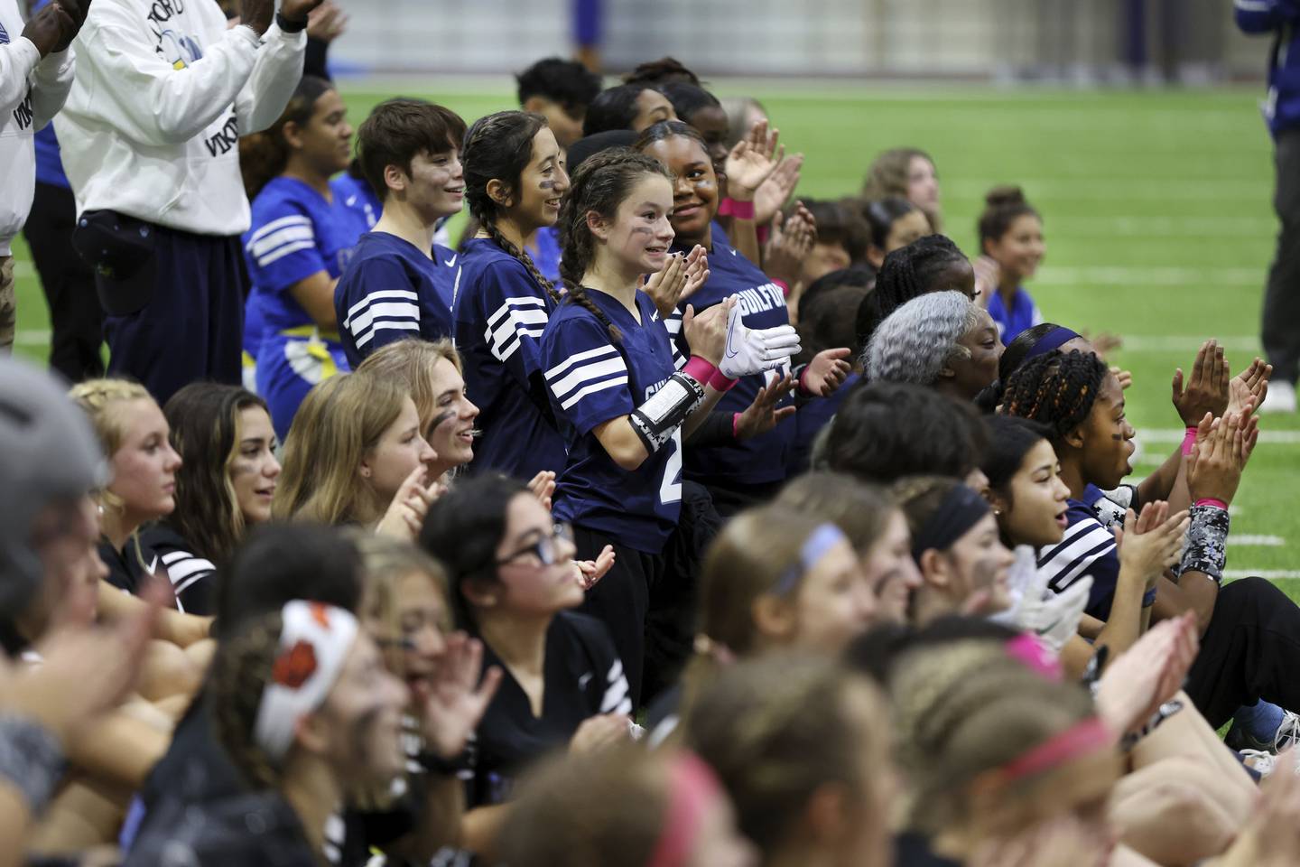 Members of the Rockford Guilford High School team applaud as players from all four teams collect at the 50 yard line before the semifinal game at the first-ever “Chicago Bears Girls Flag State Championship” at Halas Hall in Lake Forest on Oct. 29, 2022.   