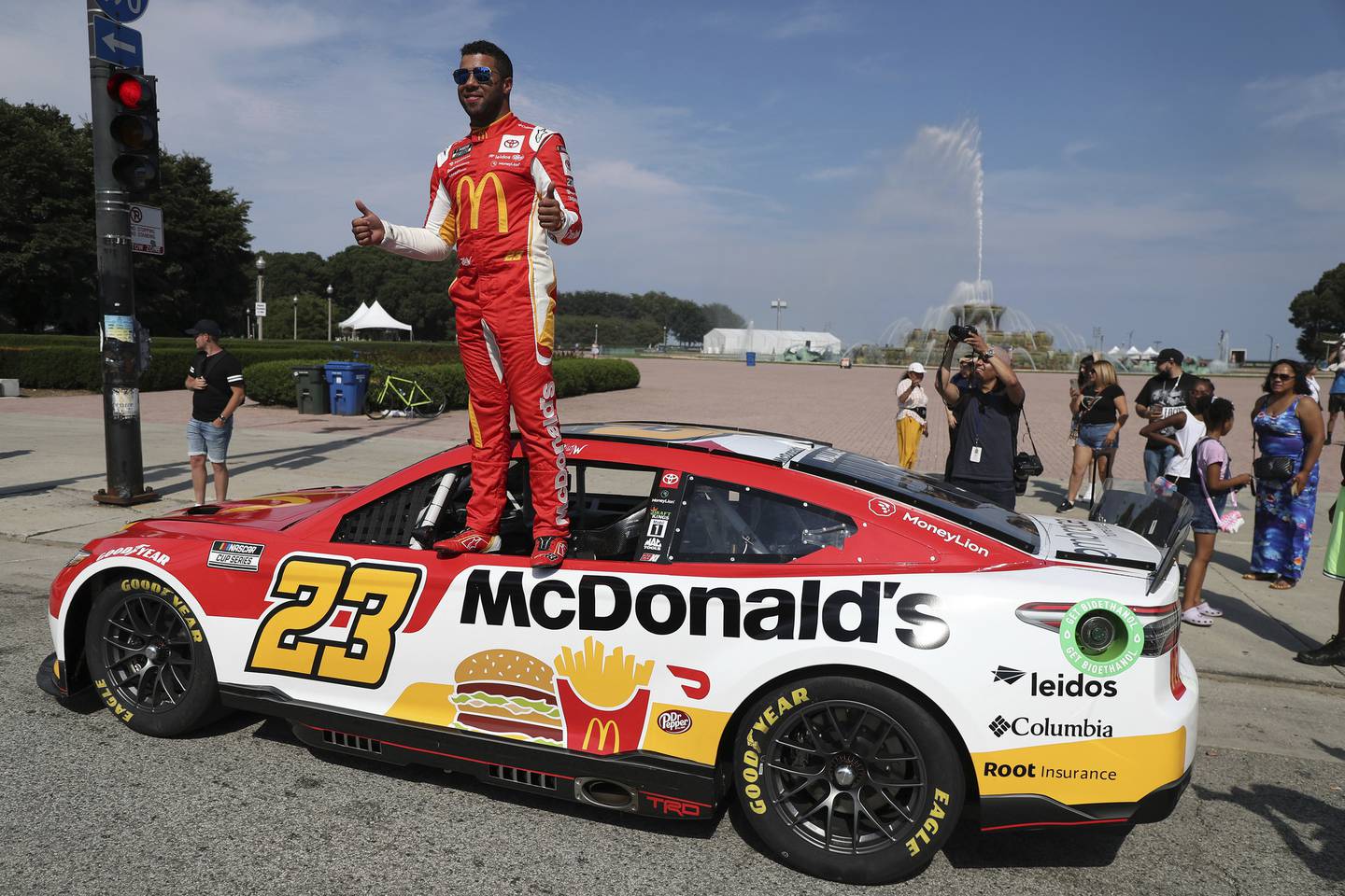 NASCAR driver Bubba Wallace stands on a race car during a promotional event near Buckingham Fountain in Chicago on July 19, 2022.