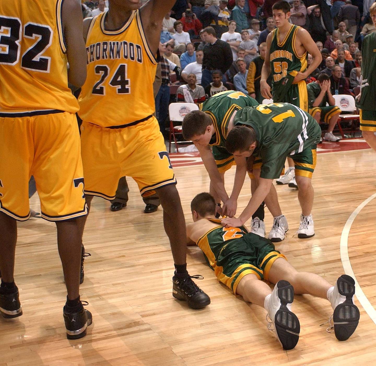 Glenbrook North's Jon Scheyer lies on the floor as Thornwood celebrates its victory in the IHSA Class AA state semifinals on March 22, 2003, in Peoria.