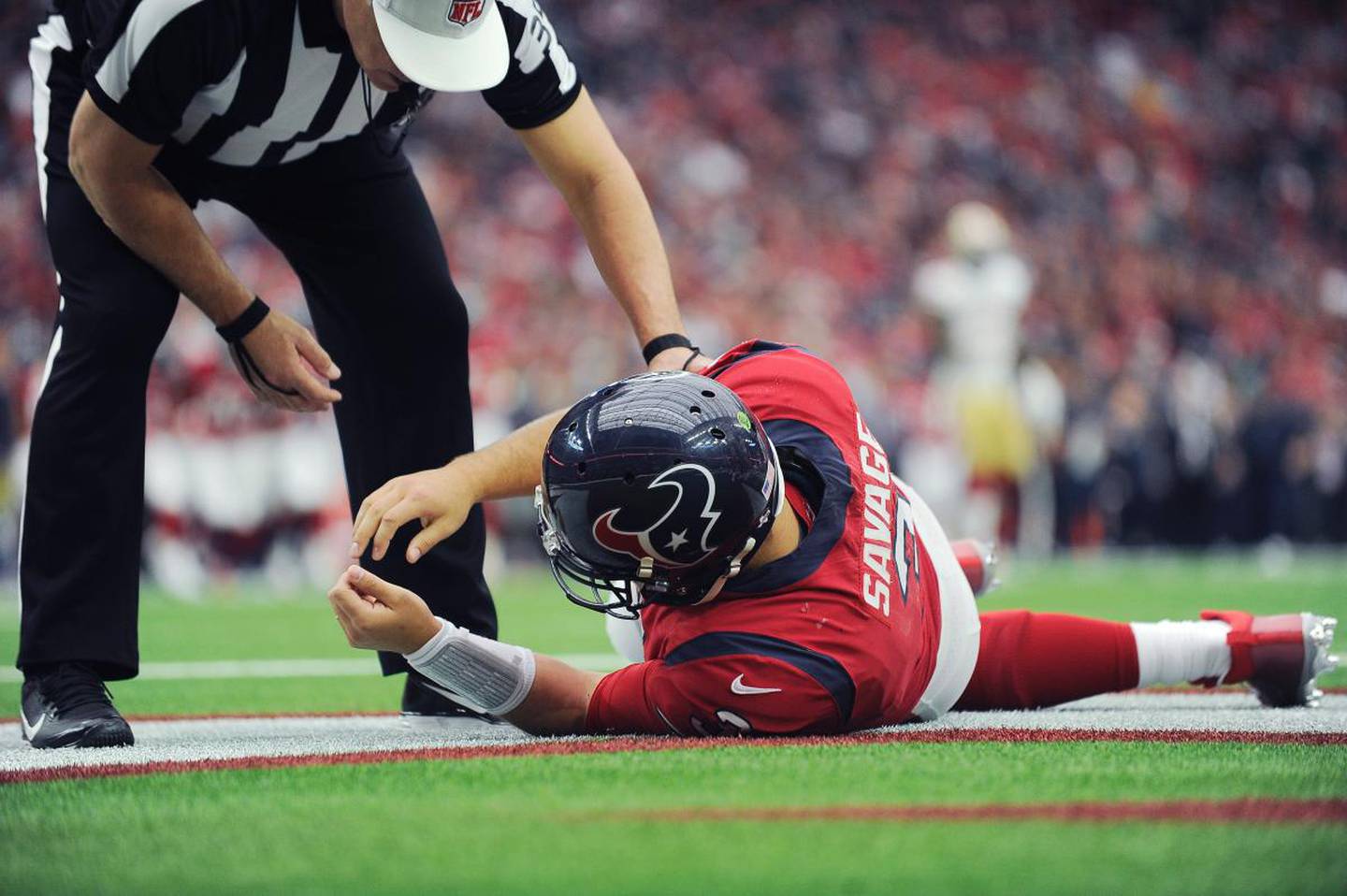 Texans quarterback Tom Savage is checked by a referee after he was hit during the first half of a game against the 49ers on Dec. 10, 2017, in Houston. Savage left the game. 