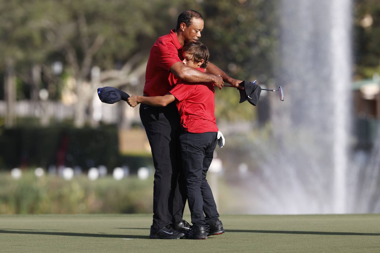 Tiger Woods hugs son Charlie Woods on the 18th green after the second round of the 2021 PNC Father-Son Challenge in Orlando.