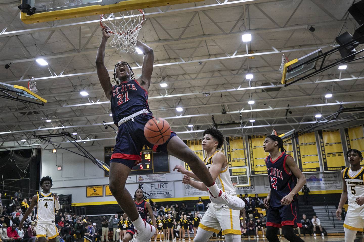 St. Rita's Morez Johnson (21) reacts as he finishes off a slam dunk against St. Laurence during a Catholic League crossover in Burbank on Tuesday, Dec. 13, 2022.