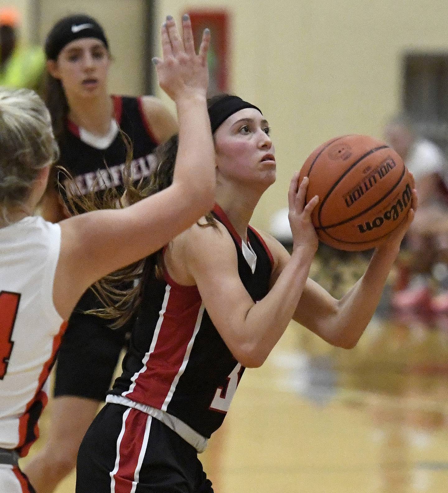 Deerfield’s Aubrey Galvan, right, shoots in front of Libertyville’s Kate Rule during a game in Libertyville on Saturday, Dec. 10, 2022. 
