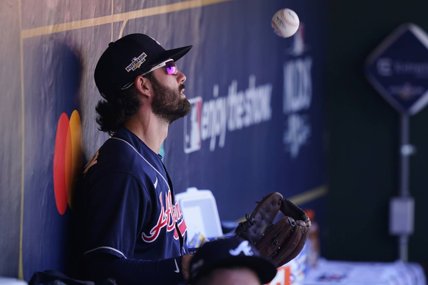 The Braves' Dansby Swanson tosses a ball in the dugout before a playoff game on Oct. 15, 2022, in Philadelphia.