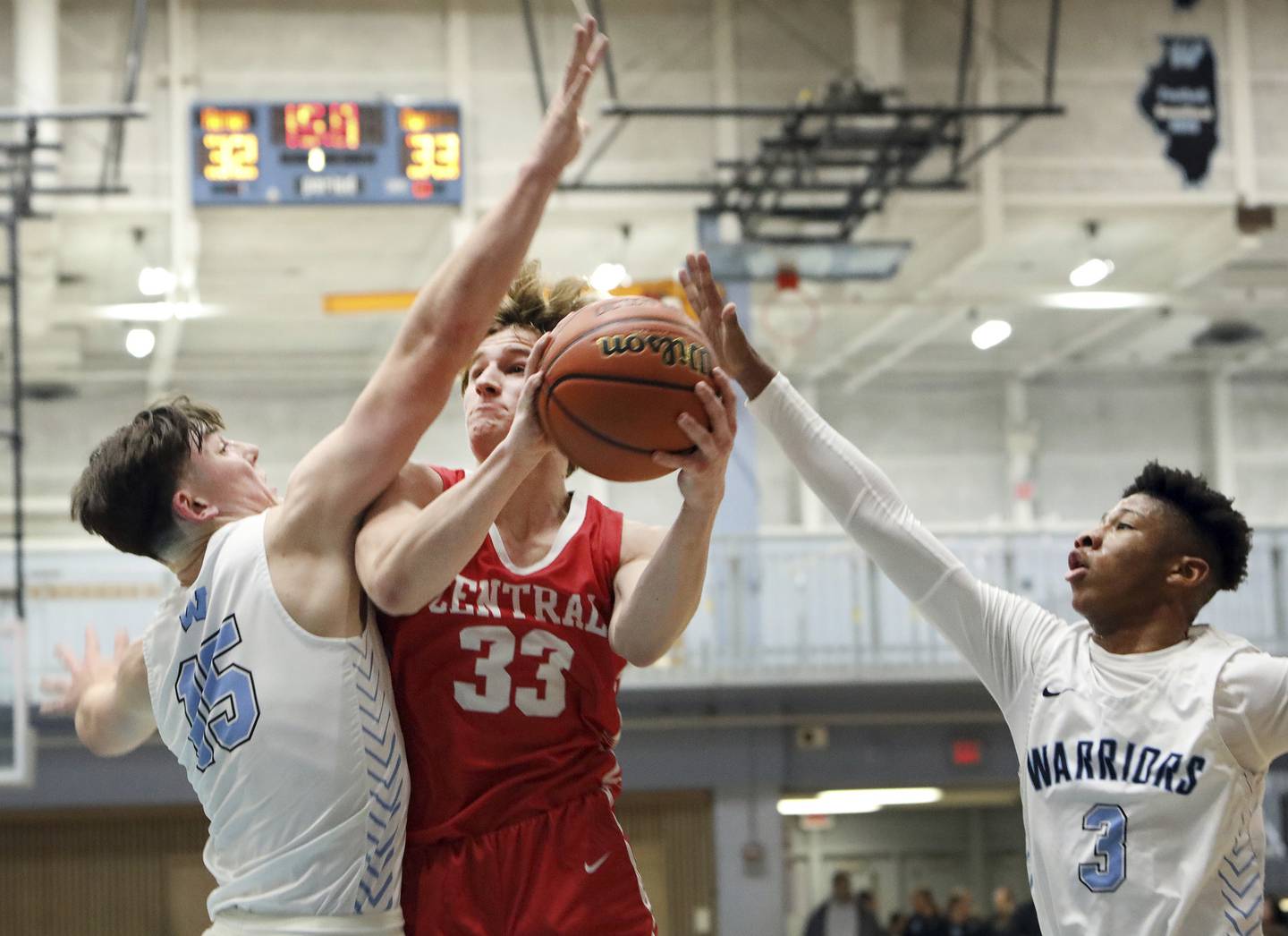 Naperville Central’s Ross DeZur, center, takes the ball to the basket against Willowbrook’s Isaac Sobieszczyk, left, and Tyler Royal during a game in Villa Park on Wednesday, Dec. 7, 2022. 