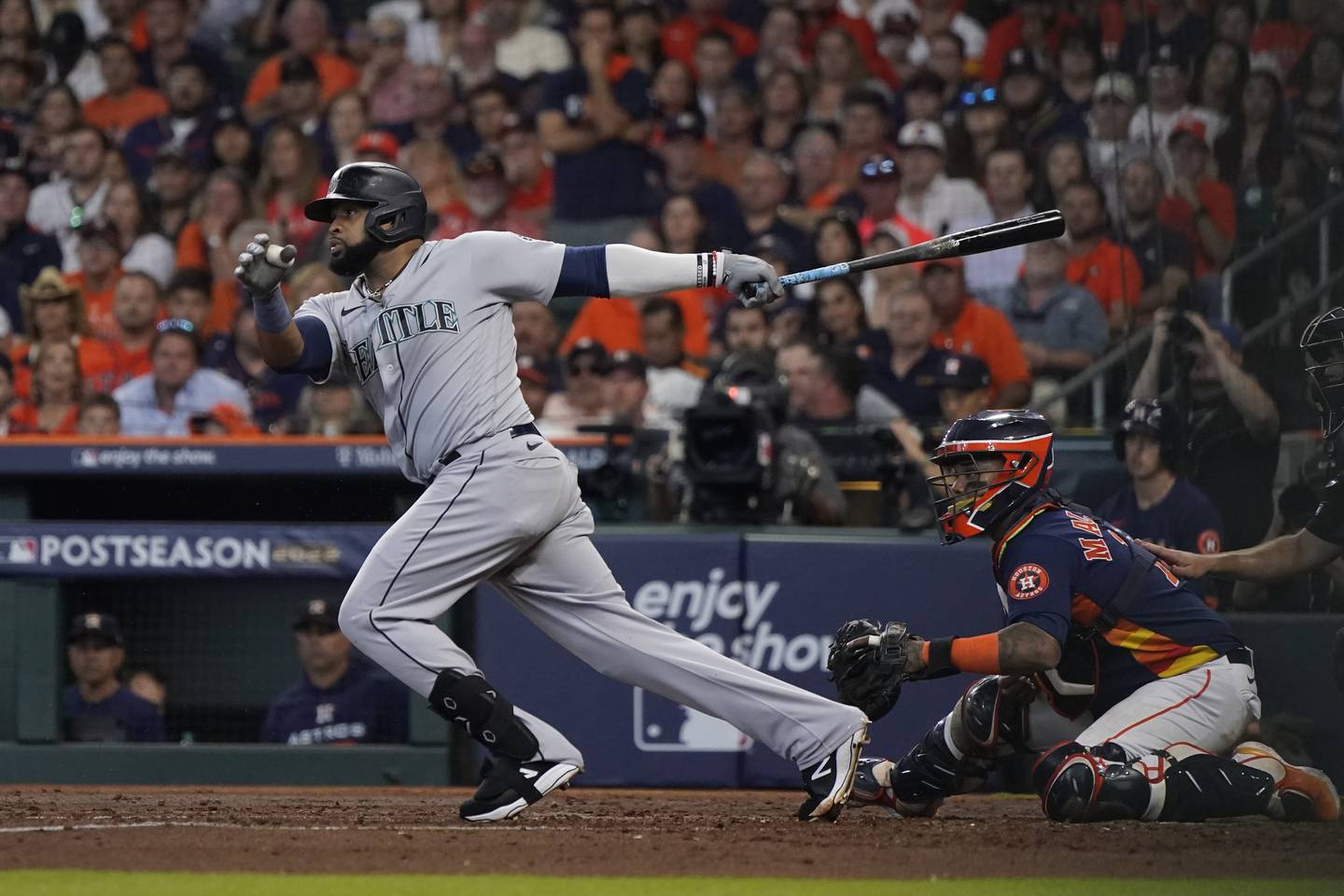 The Mariners' Carlos Santana hits against the Astros to score a run during the fourth inning of a playoff game on Oct. 13, 2022.