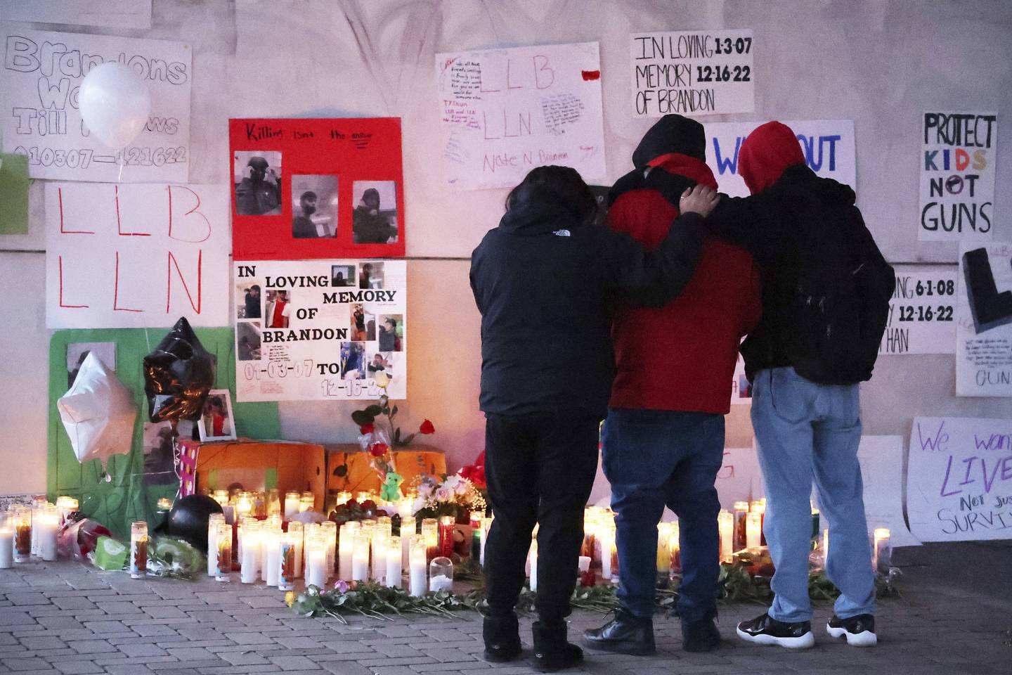 People stop at a memorial at Benito Juarez Community Academy high school in Chicago on Dec. 19, 2022, days after four teens were shot there, two of them fatally. 