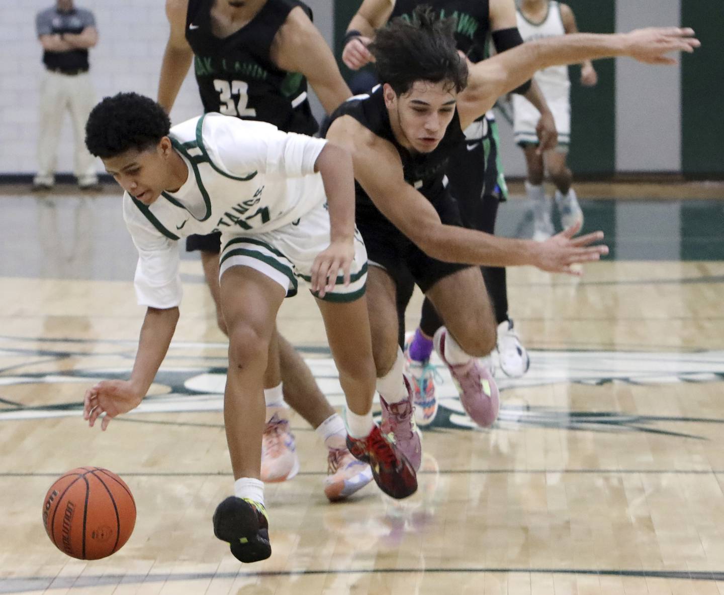 Evergreen Park's Ulises Cardenas, left, charges down court past Oak Lawn's Eduardo Chiquito during a South Suburban Red game in Evergreen Park on Thursday, Dec. 8, 2022.