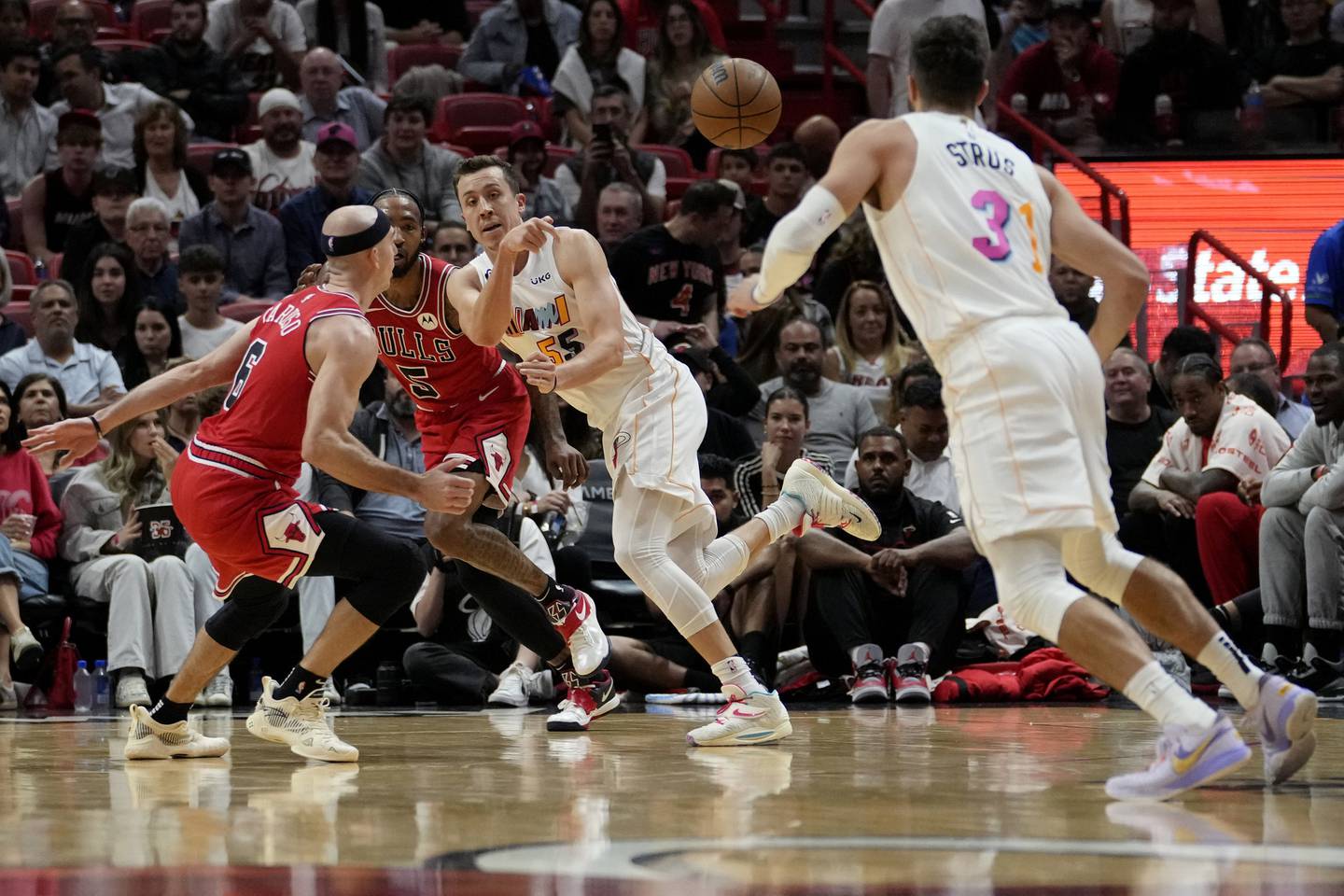 Heat forward Duncan Robinson, center, passes the ball to guard Max Strus as Bulls guard Alex Caruso defends during the first half on Dec. 20, 2022.