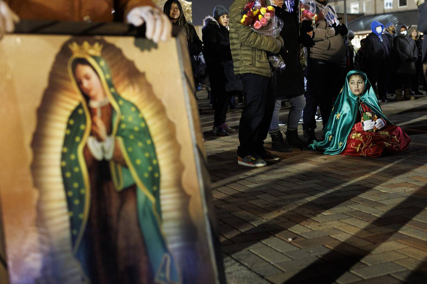 Dressed as Our Lady of Guadalupe, Guadalupe Lopez, 10, sits on the ground while attending a service near the Shrine of Our Lady of Guadalupe on Dec. 11, 2022, in Des Plaines. 