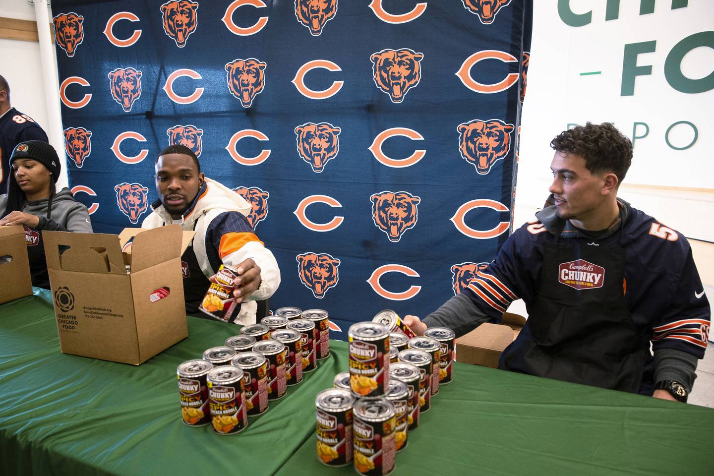 Bears safety Eddie Jackson, left, and linebacker Sterling Weatherford help pack boxes at the Greater Chicago Food Depository on Monday, Dec. 19, 2022.