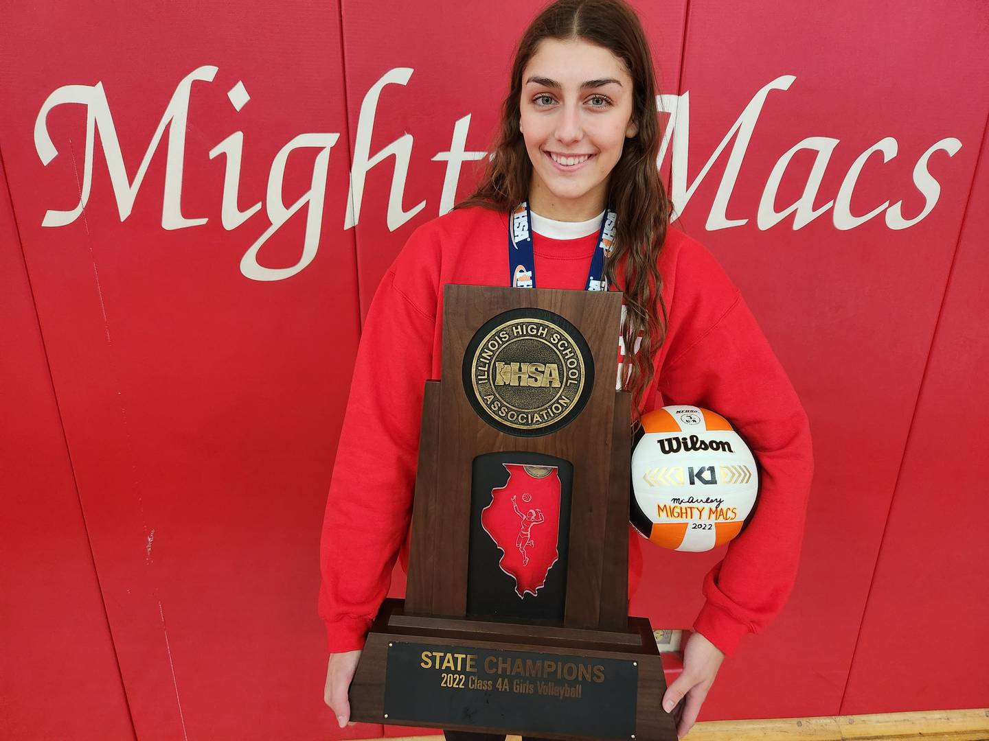 Mother McAuley's Ellie White shows the Class 4A state championship trophy after the team was honored at an assembly on Monday, Nov. 14, 2022.