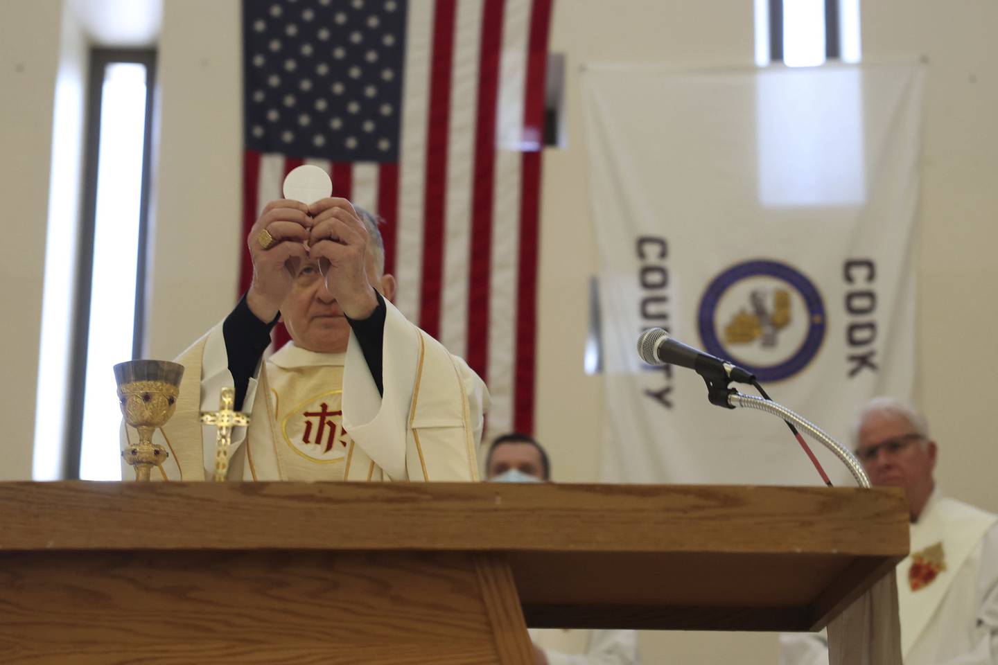 Cardinal Blase Cupich holds up bread for communion during morning Christmas Mass at Cook County Jail Sunday. 