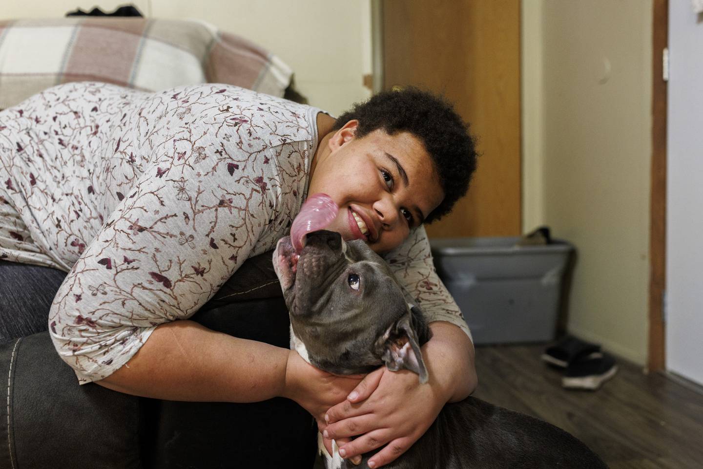 Destiny, 19, who graduated from Garrison in 2021, plays with her family’s dog inside their home. 