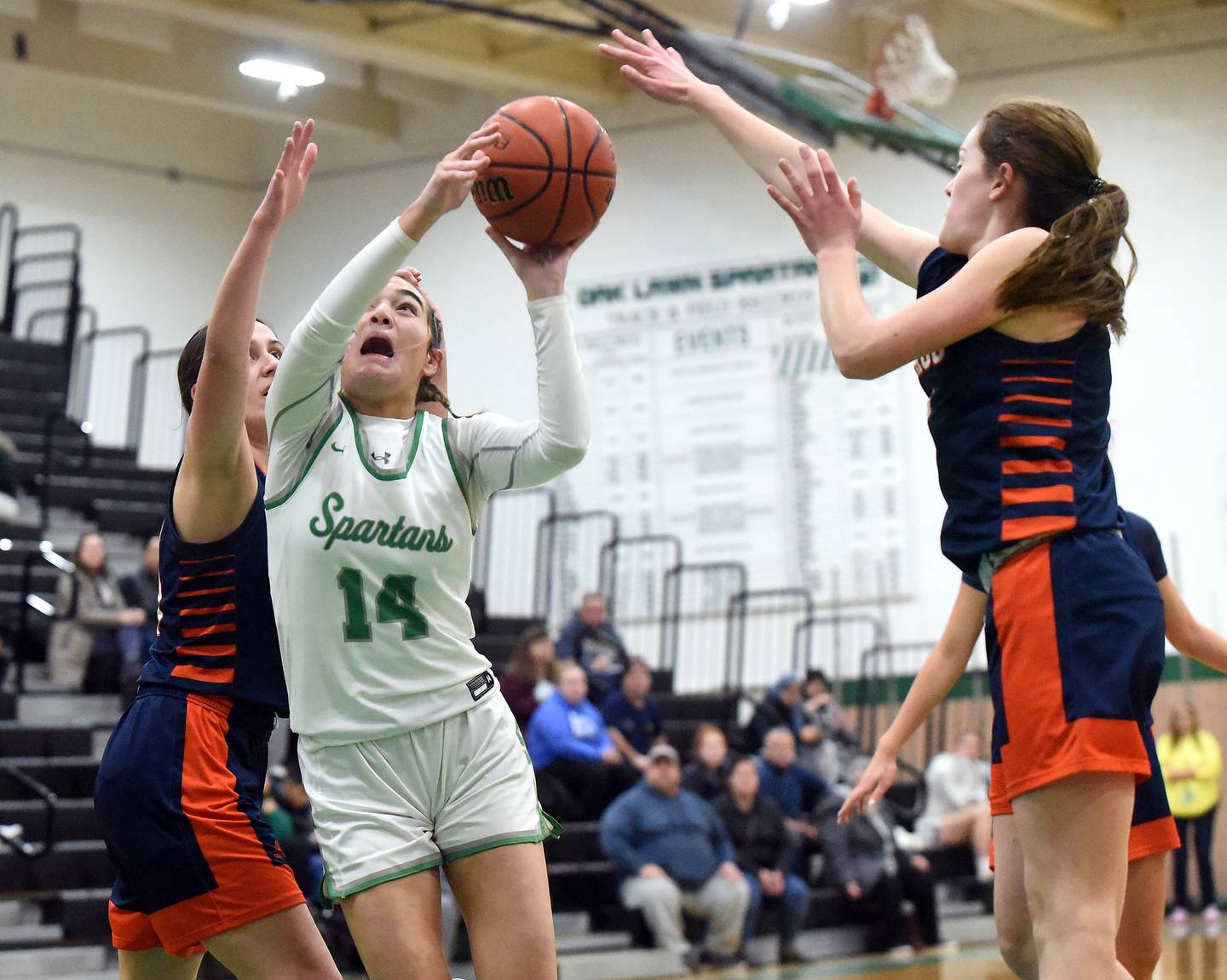 Oak Lawn's Danielle Dempsey (14) splits two Stagg defenders on her way to the basket during a nonconference game in Oak Lawn on Tuesday, Dec. 20, 2022.