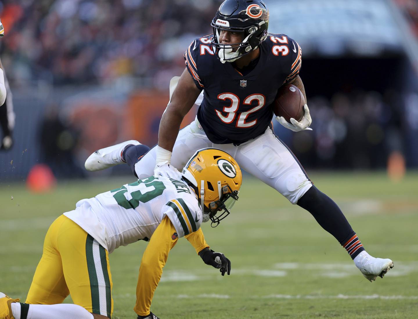 Bears running back David Montgomery (32) leaps over Packers cornerback Jaire Alexander (23) on Dec. 4, 2022, at Soldier Field.