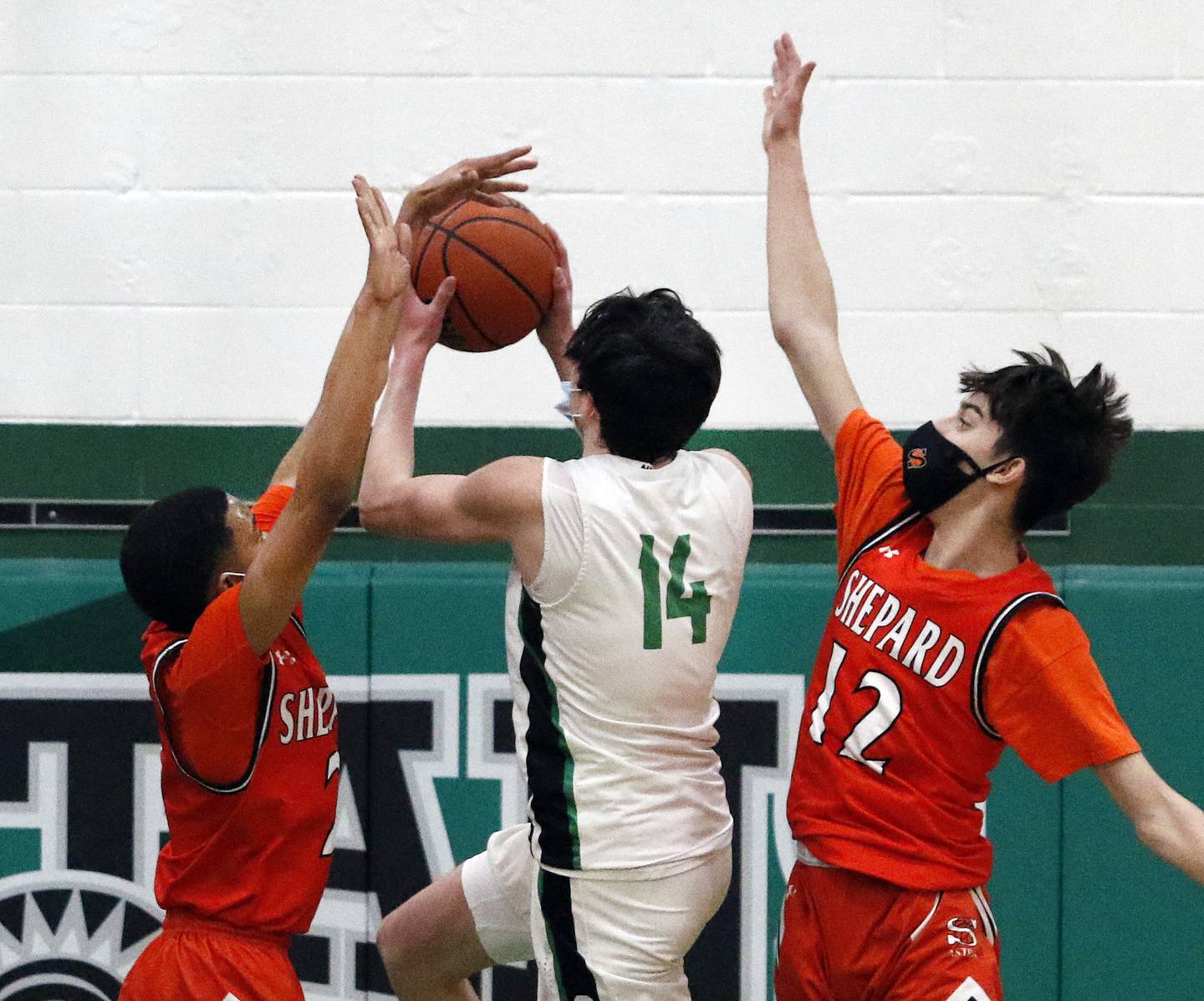 Oak Lawn's John McGowan drives through Shepard's Payton Crims, left, and Kevin Plascencia during a South Suburban Red game on Friday, Feb, 19, 2021.