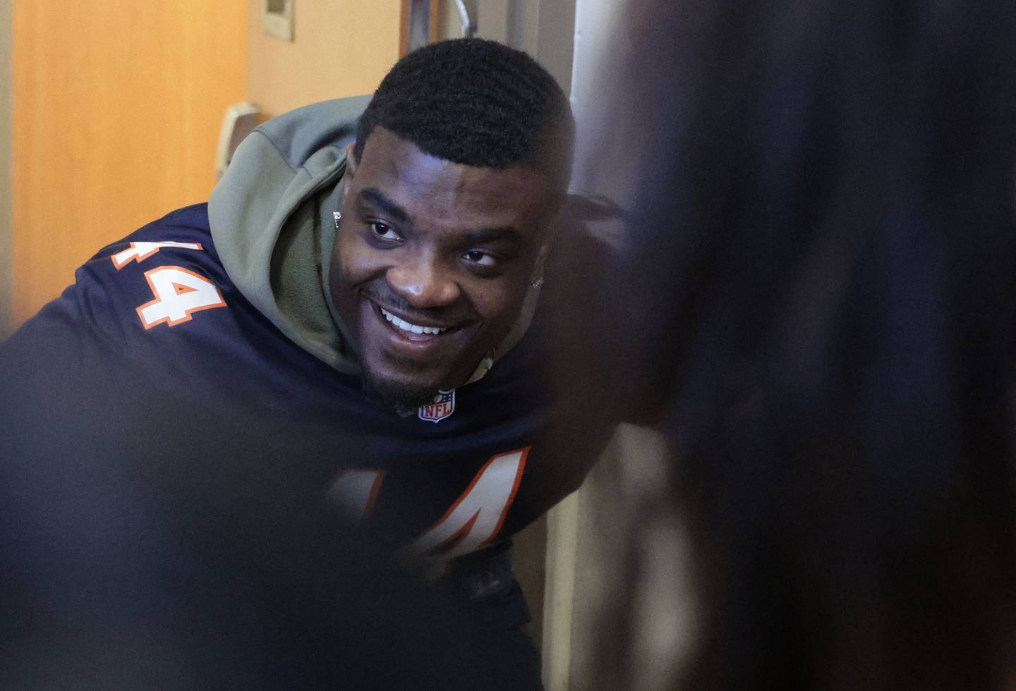 Chicago Bears linebacker Matthew Adams gives away Bears hats and took photos with guests at the Salvation Army's party for Venezuelan migrants on Dec. 19, 2022.   