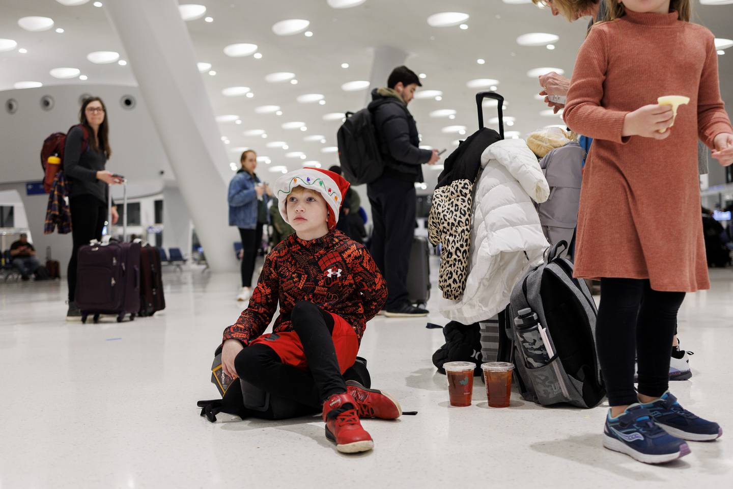 Sebastian, 7, sits on the floor while waiting to board a flight to Colorado in Terminal 5 of O’Hare International Airport shortly before a snowstorm and below-freezing conditions arrive in the area on Dec. 22, 2022, in Chicago.