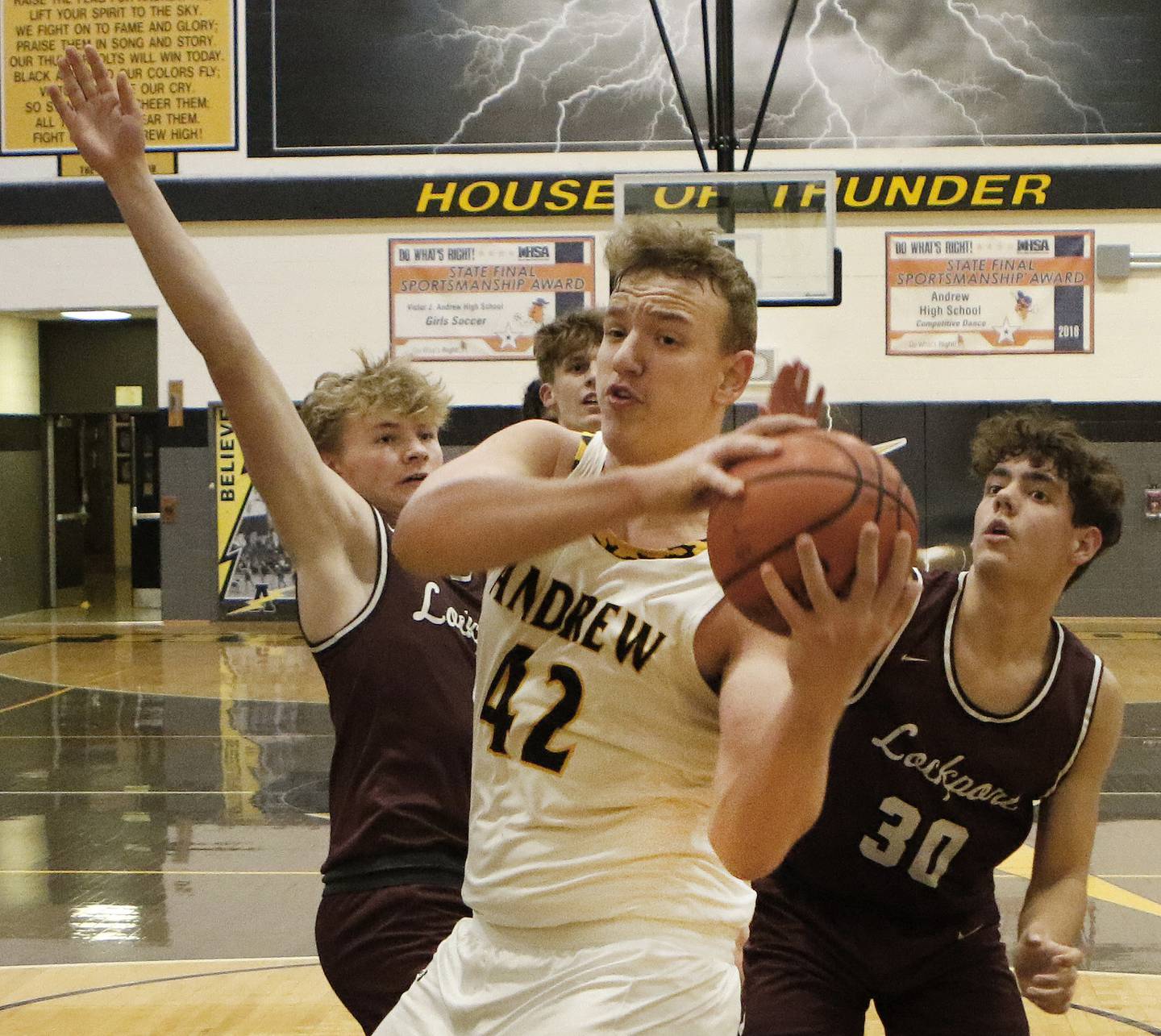 Andrew's Grantas Sakenis (42) looks to pass under the basket away from Lockport's Adam Labuda, left, and Evan Dziadkowiec during a SouthWest Suburban Conference crossover on Friday, Dec. 9, 2022.