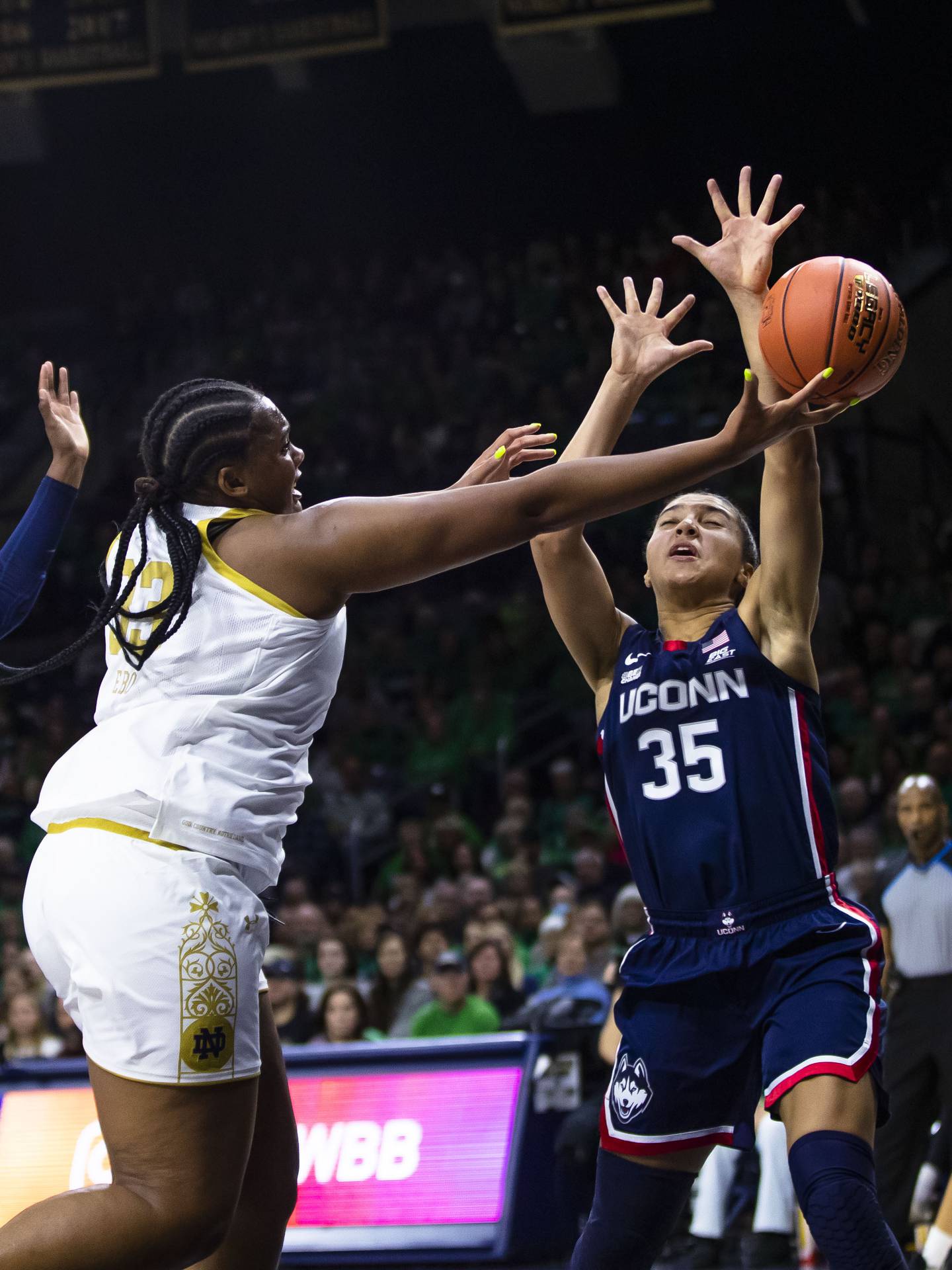 Notre Dame's Lauren Ebo (33) drives as Connecticut's Azzi Fudd (35) defends her during the first half of an NCAA college basketball game on Sunday, Dec. 4, 2022, in South Bend, Ind. (AP Photo/Michael Caterina)