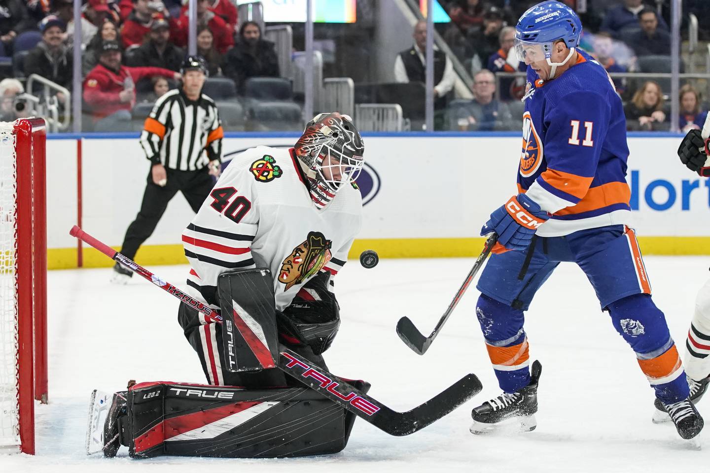 Blackhawks goalie Arvid Söderblom makes a save next to the Islanders'Zach Parise during the second period on Dec. 4, 2022.