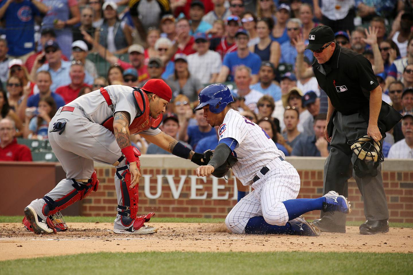 Cubs catcher Willson Contreras, right, misses the plate as he's tagged out by Cardinals catcher Yadier Molina during the third inning on Aug. 13, 2016, at Wrigley Field. 